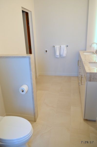 A bathroom with a toilet a sink and a towel rack