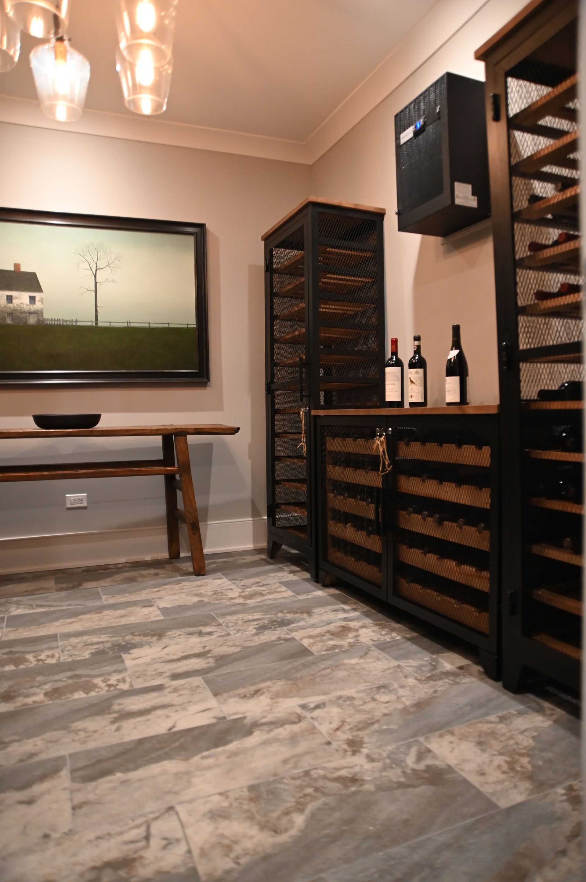 A wine cellar with bottles of wine and a painting on the wall.