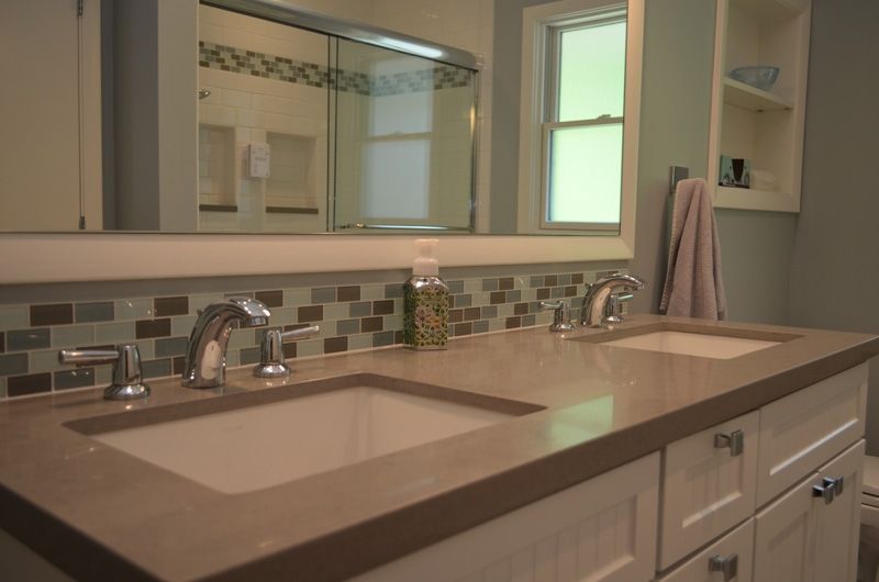 A bathroom with two sinks and a mirror.