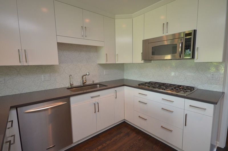 A kitchen with white cabinets and stainless steel appliances
