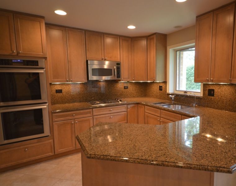 A kitchen with wooden cabinets and granite counter tops