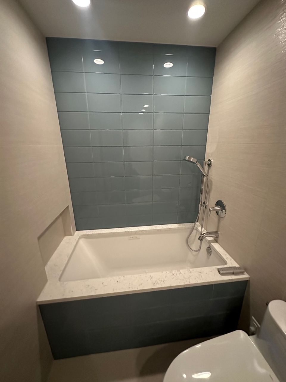 A bathroom with a bathtub , toilet and shower.