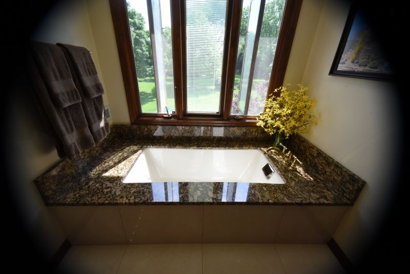 A bathtub in a bathroom next to a window