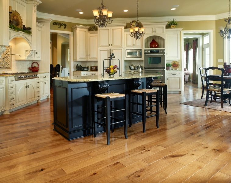 A kitchen with a large island and wooden floors