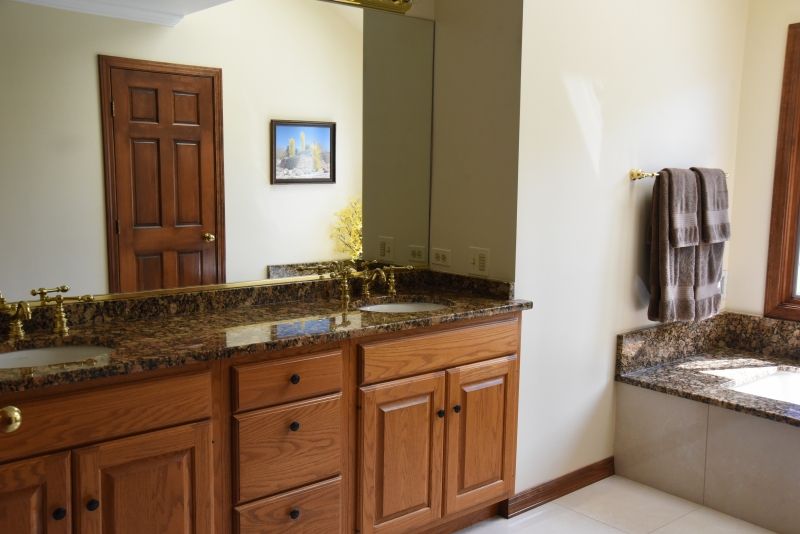 A bathroom with two sinks , a tub and a mirror.