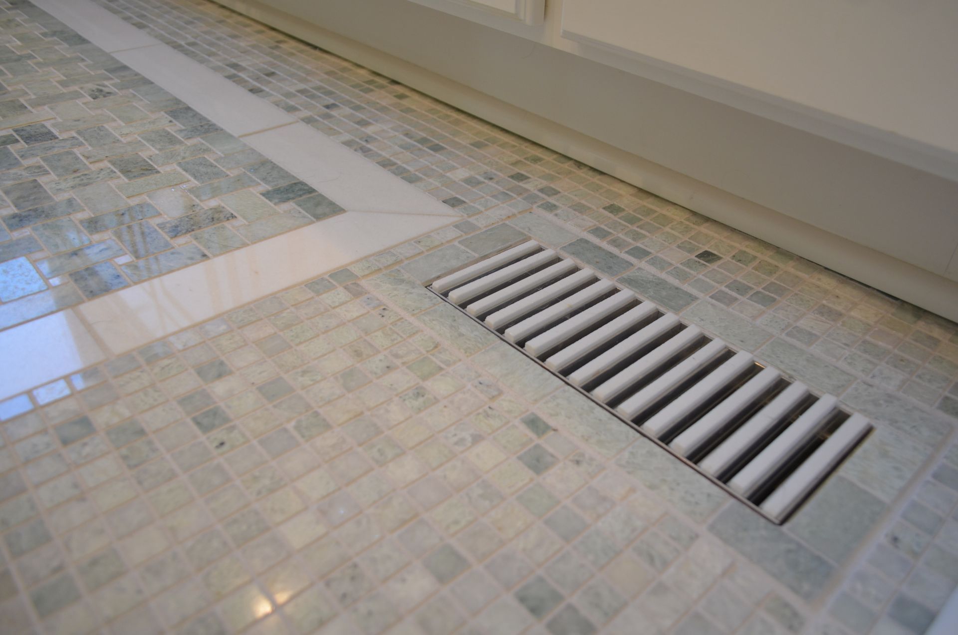 A tiled floor with a drain on it