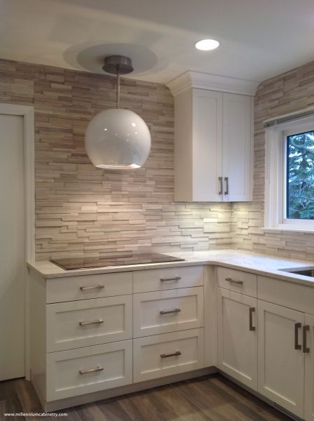 A kitchen with white cabinets and a stove top oven