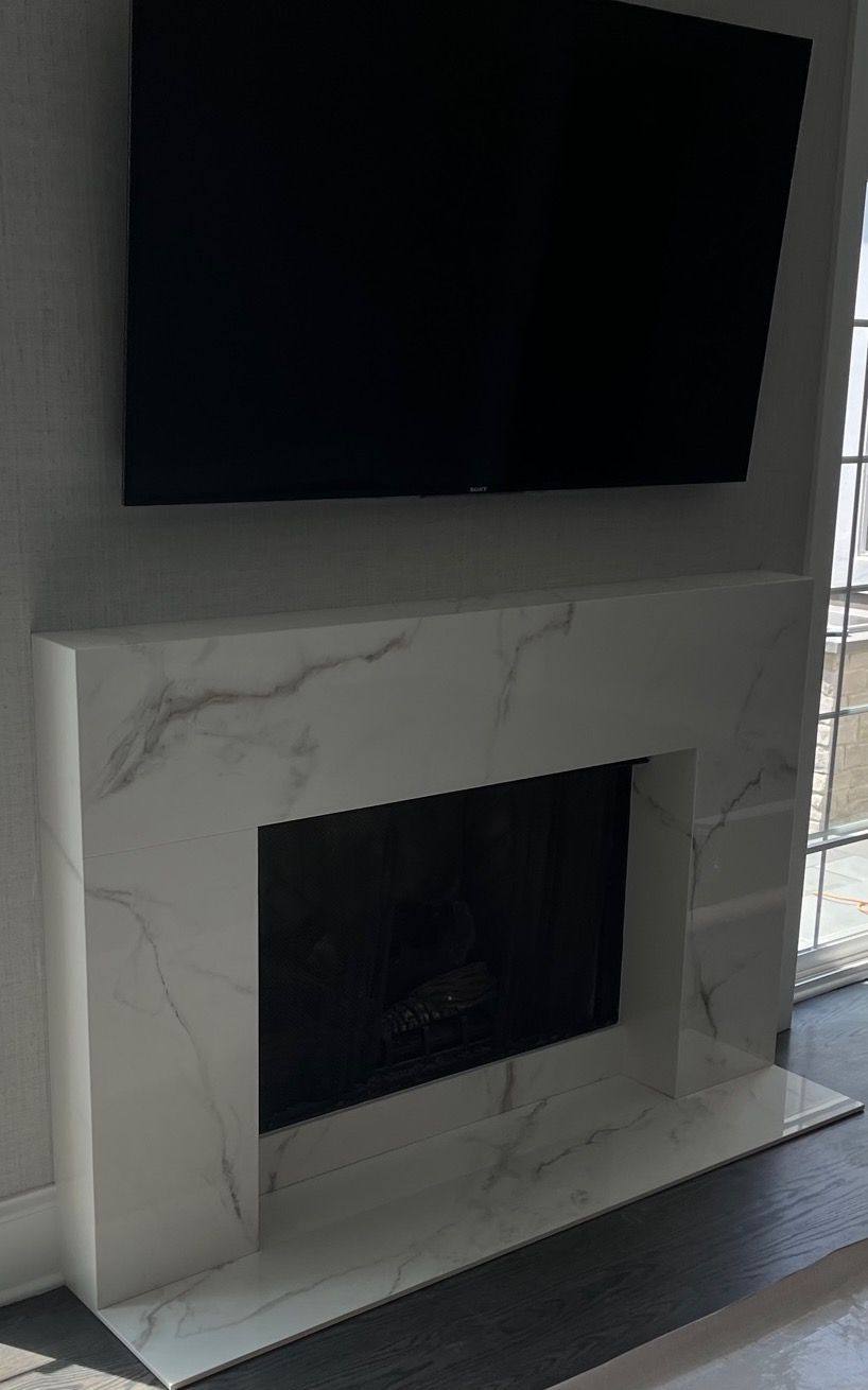 A fireplace with a flat screen tv mounted above it.