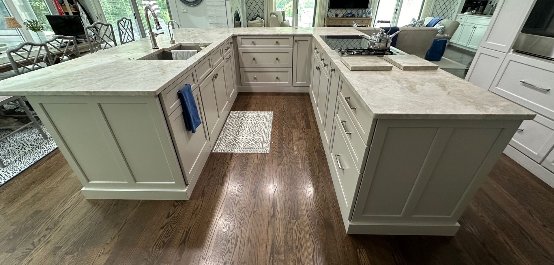 A kitchen with white cabinets , granite counter tops , and hardwood floors.