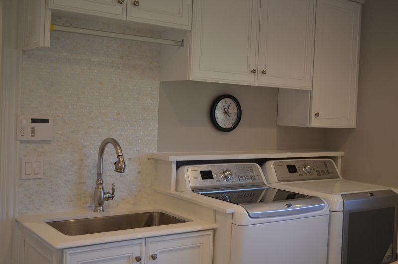 A laundry room with a washer and dryer and a sink
