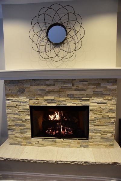 A fireplace with a mirror on the wall above it