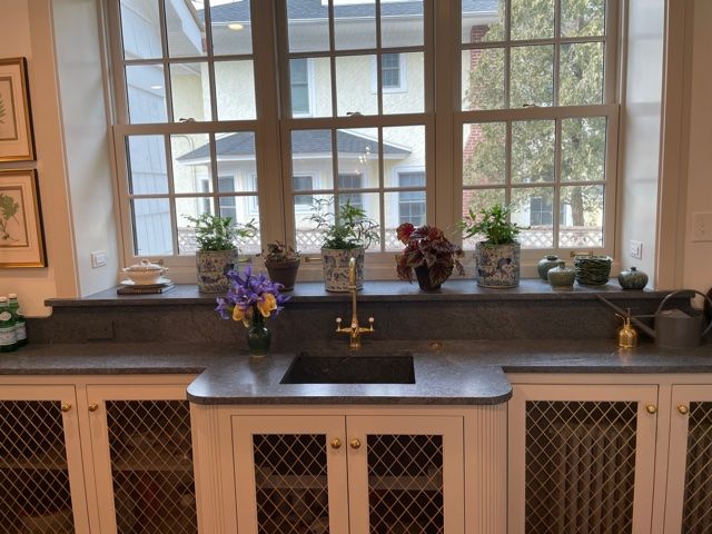 A kitchen with a sink and potted plants on a window sill