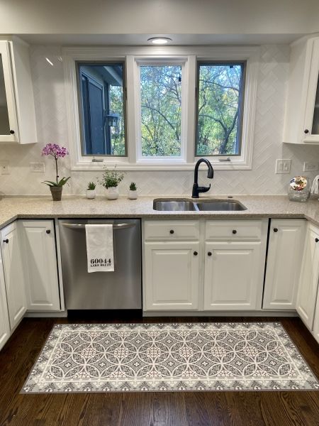 A kitchen with white cabinets and a stainless steel dishwasher