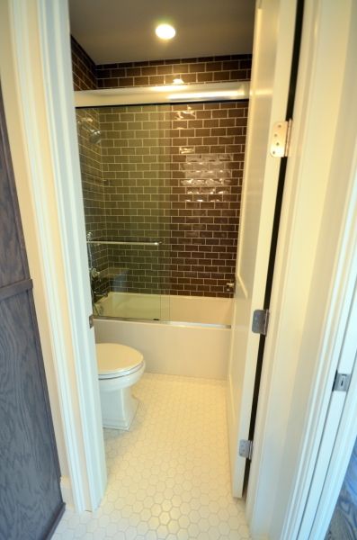 A bathroom with a toilet , tub and shower.