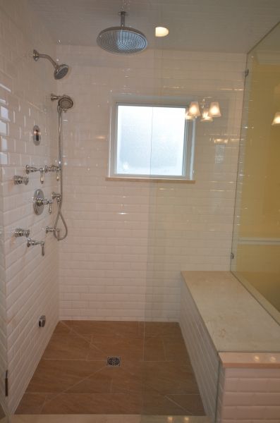 A bathroom with a walk in shower and a window