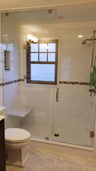 A bathroom with a toilet , sink , shower and window.