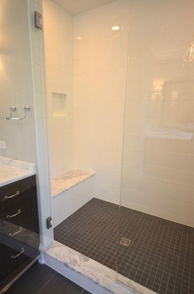A bathroom with a walk in shower and a sink