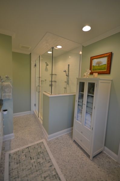 A bathroom with a walk in shower and a cabinet
