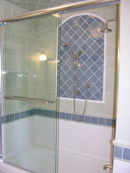 A bathroom with a sliding glass shower door
