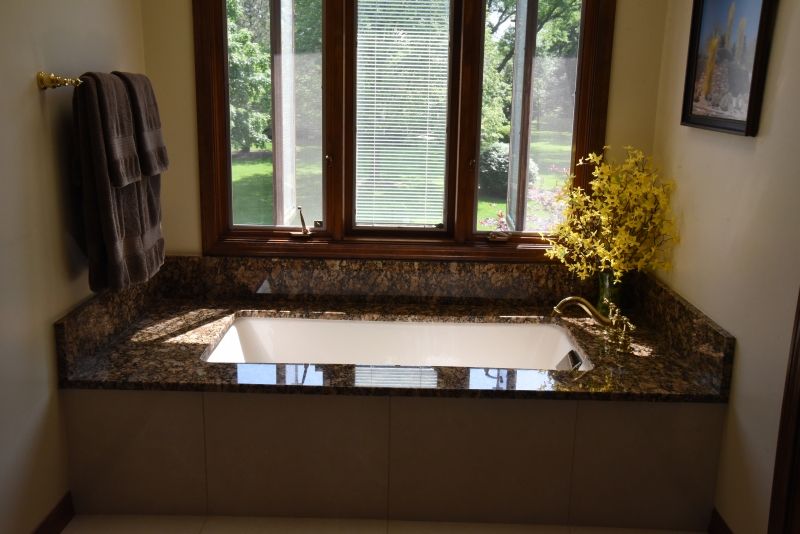 A bathroom with a bathtub and a window.
