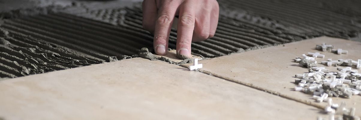 A person is laying tiles on the floor.