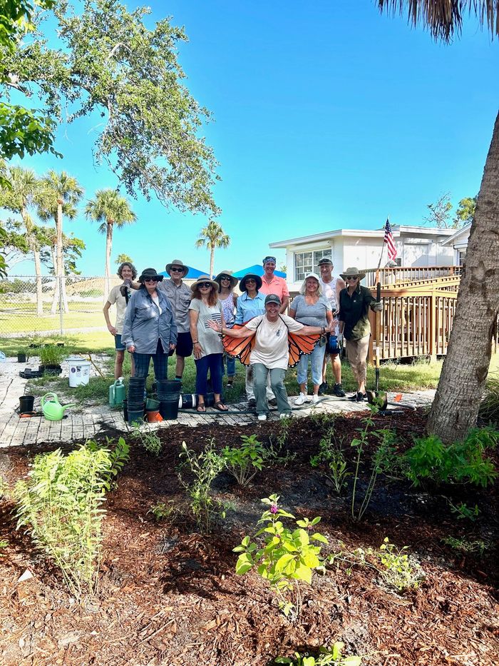 A group of people are posing for a picture in a garden.