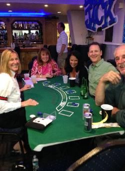 A group of people are sitting around a table playing blackjack.