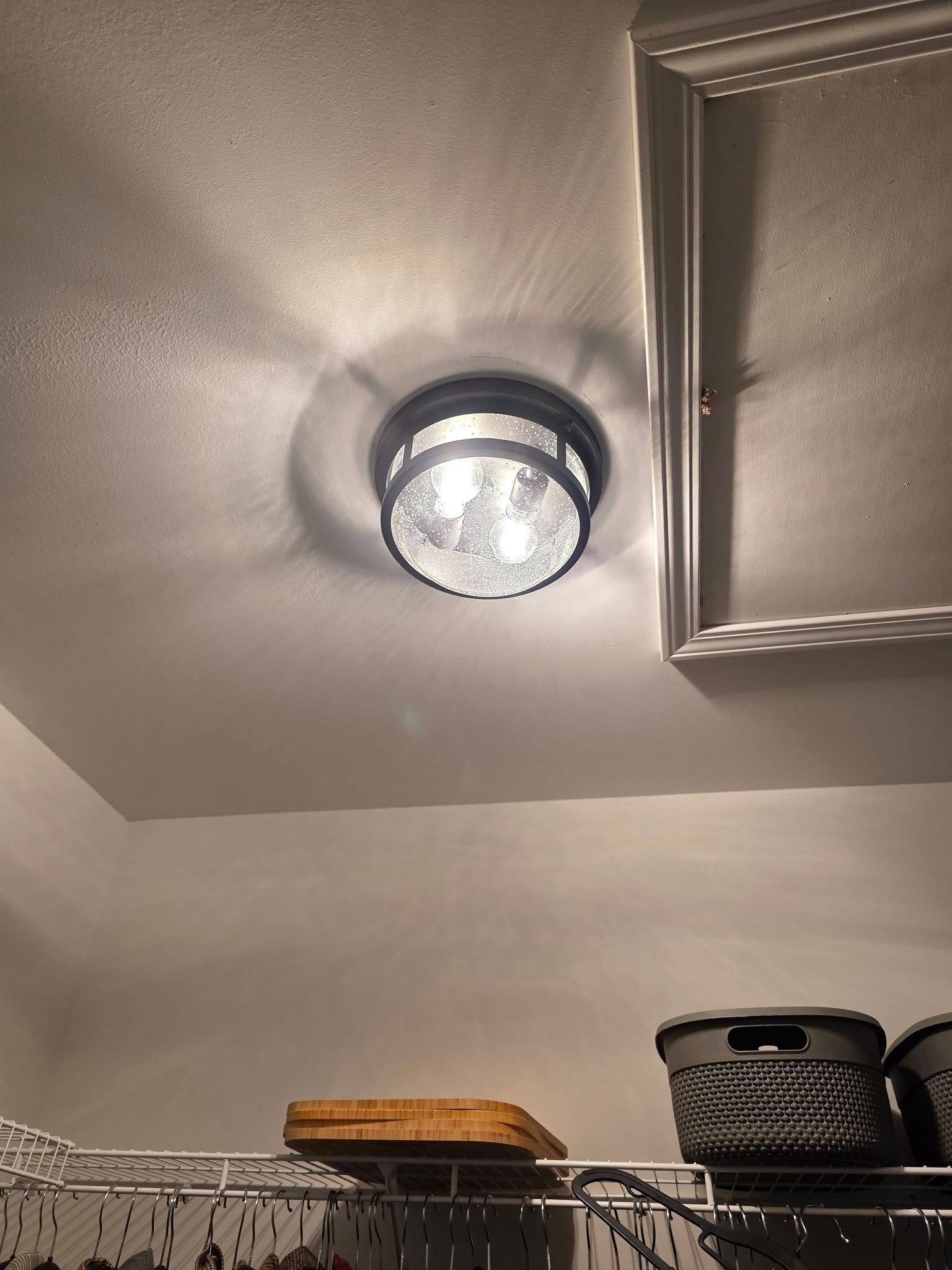 Ceiling light fixture with textured glass and black metal frame.