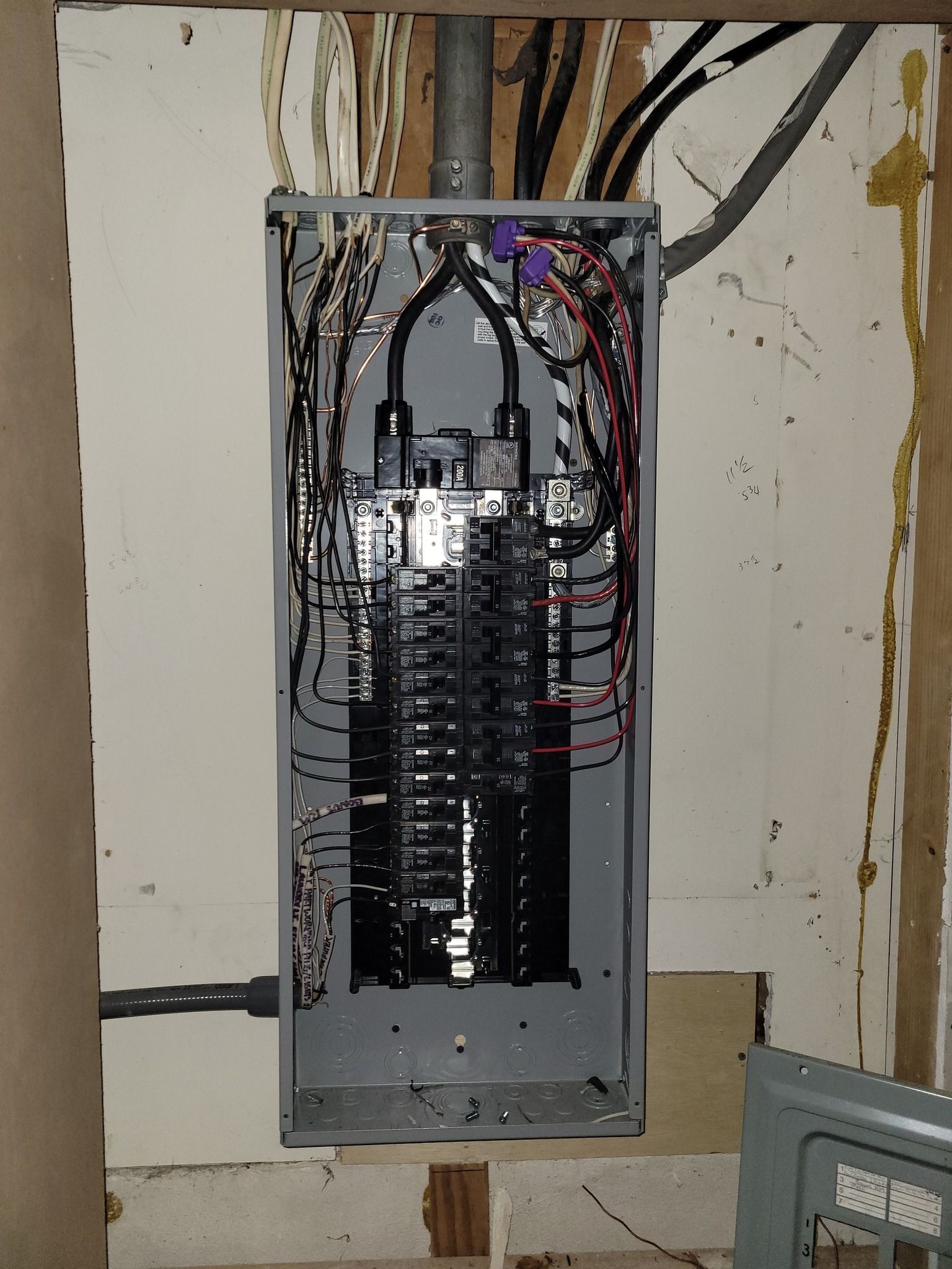 Open electrical panel with numerous wires and circuit breakers.