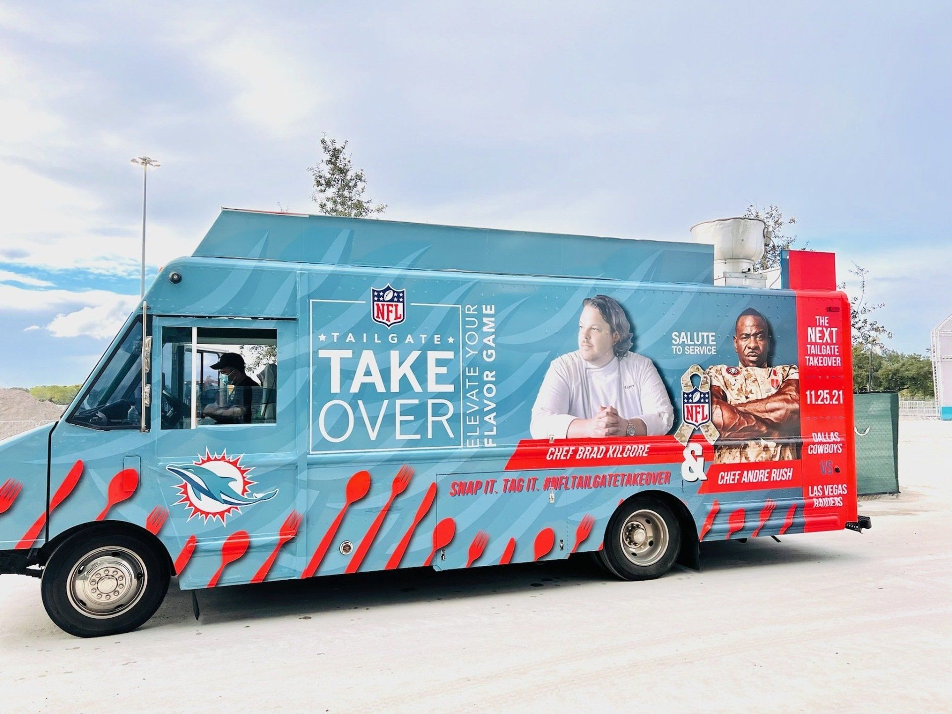 A blue and red food truck is parked in a parking lot.