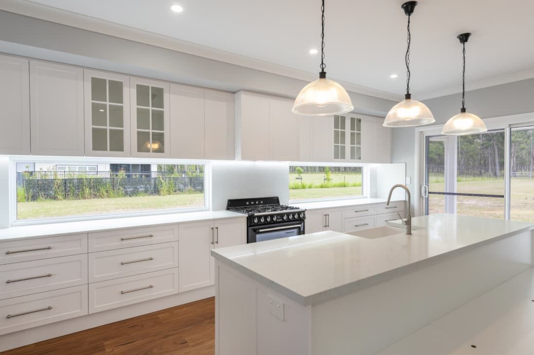 A Kitchen With White Cabinets And A Large Island — Content Stone In Trenayr, NSW