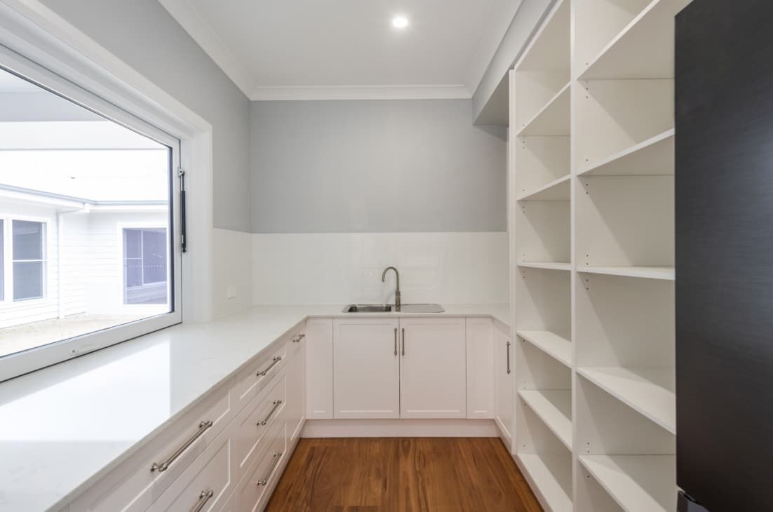 A Kitchen With White Cabinets And Shelves And A Sink — Content Stone In Coffs Harbour, NSW