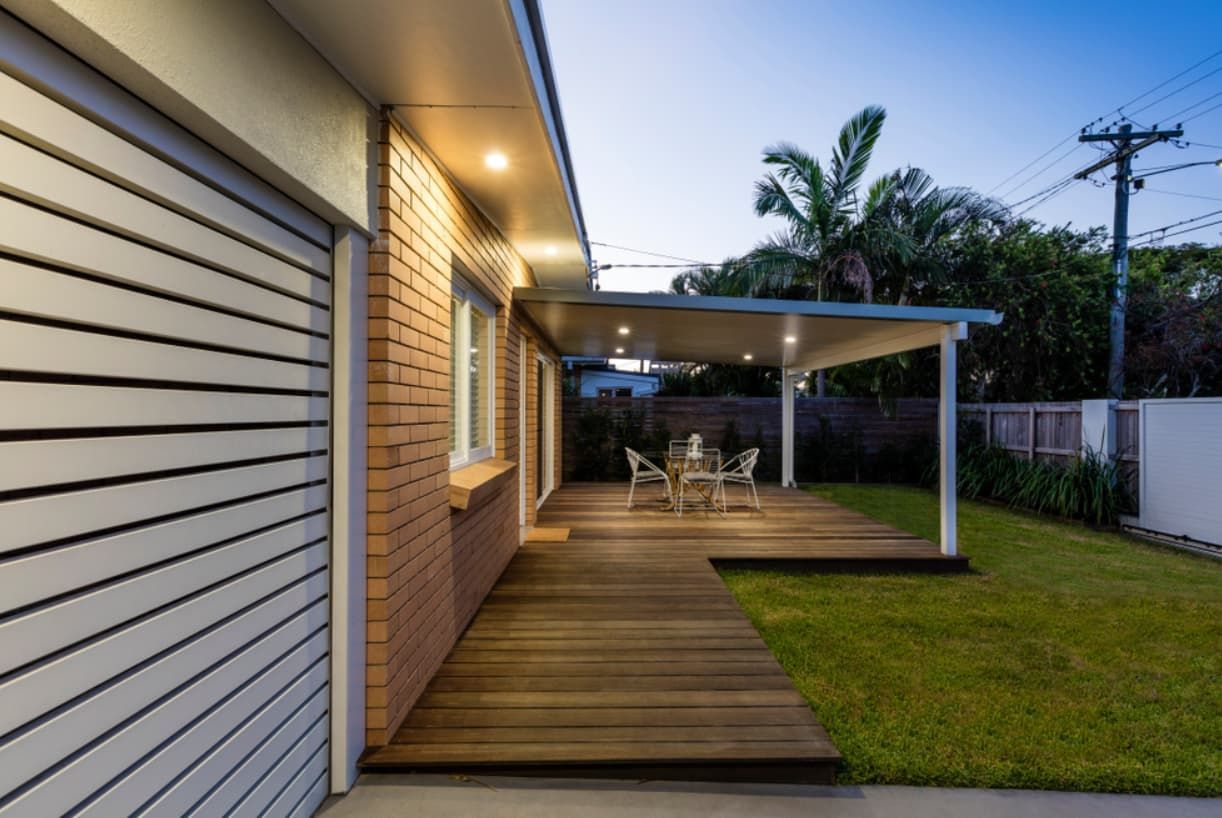 A House With A Wooden Deck And A Table And Chairs In The Backyard — Content Stone In Lismore, NSW