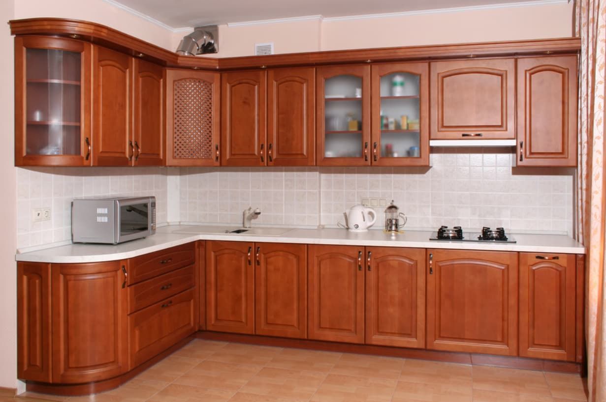 A Kitchen With Wooden Cabinets And White Counter Tops — Content Stone In Glen Innes, NSW