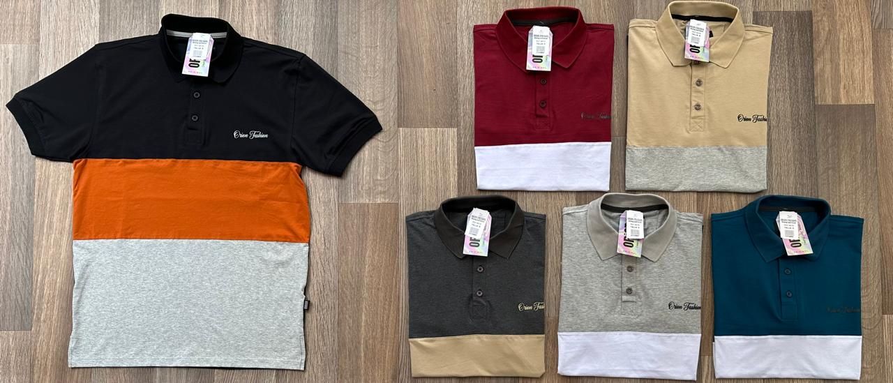 Un montón de polos están apilados uno encima del otro sobre un suelo de madera.