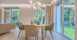 A dining room with a table and chairs and a chandelier.