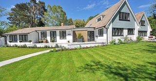 A large white house with a lush green lawn in front of it.