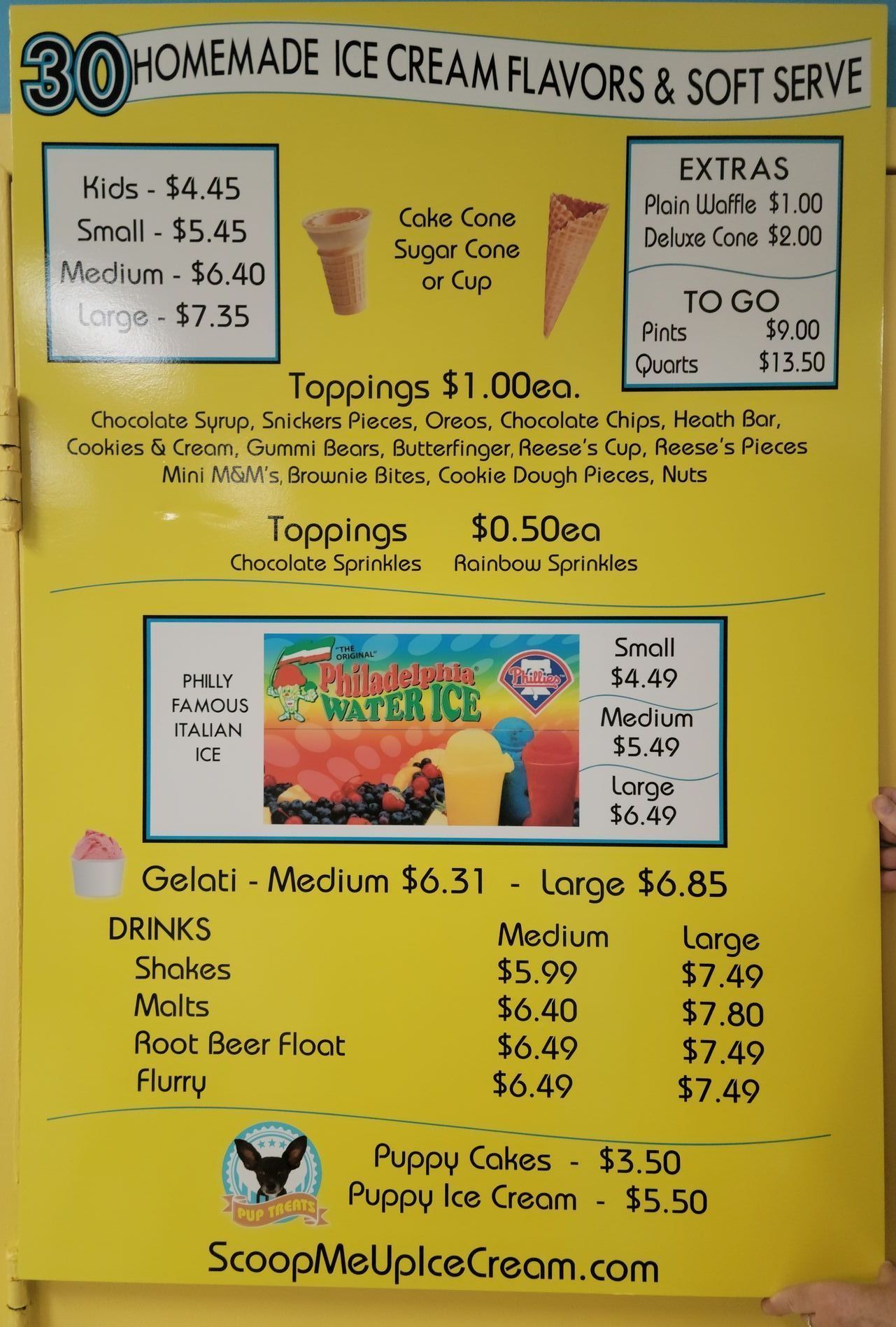 Menu board: ice cream flavors, soft serve, toppings, drinks, and treats. Yellow background, various prices listed.