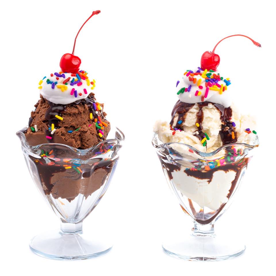 Two ice cream sundaes: chocolate and vanilla, topped with whipped cream, sprinkles, a cherry, and chocolate sauce.