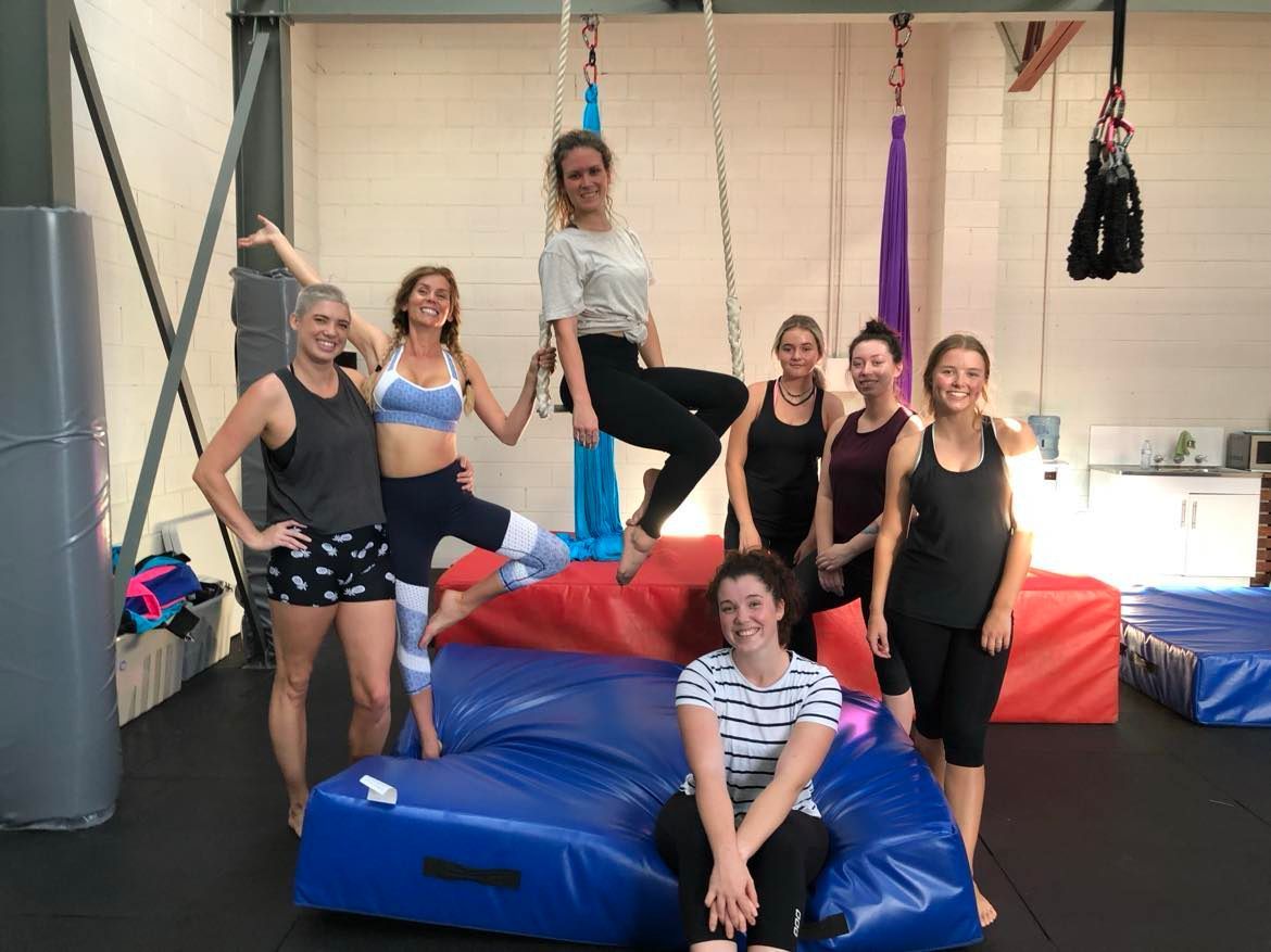 A group of women are posing for a picture in a gym.