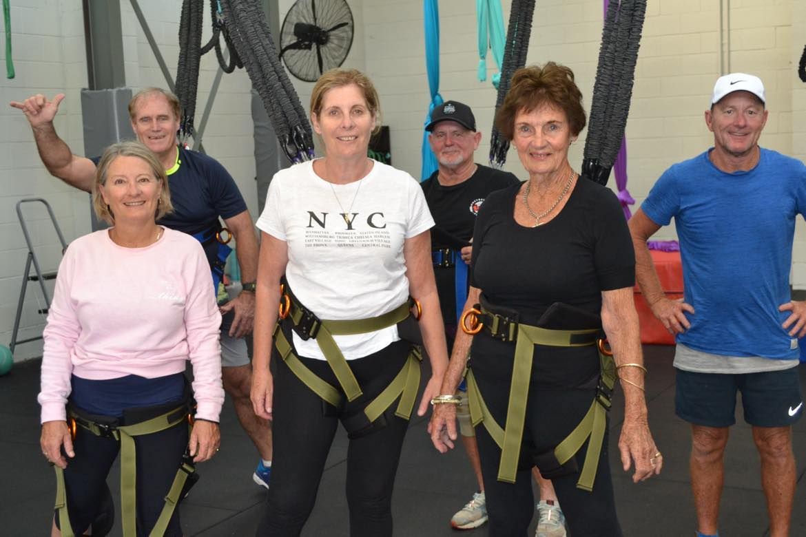 A group of people are posing for a picture in a gym.