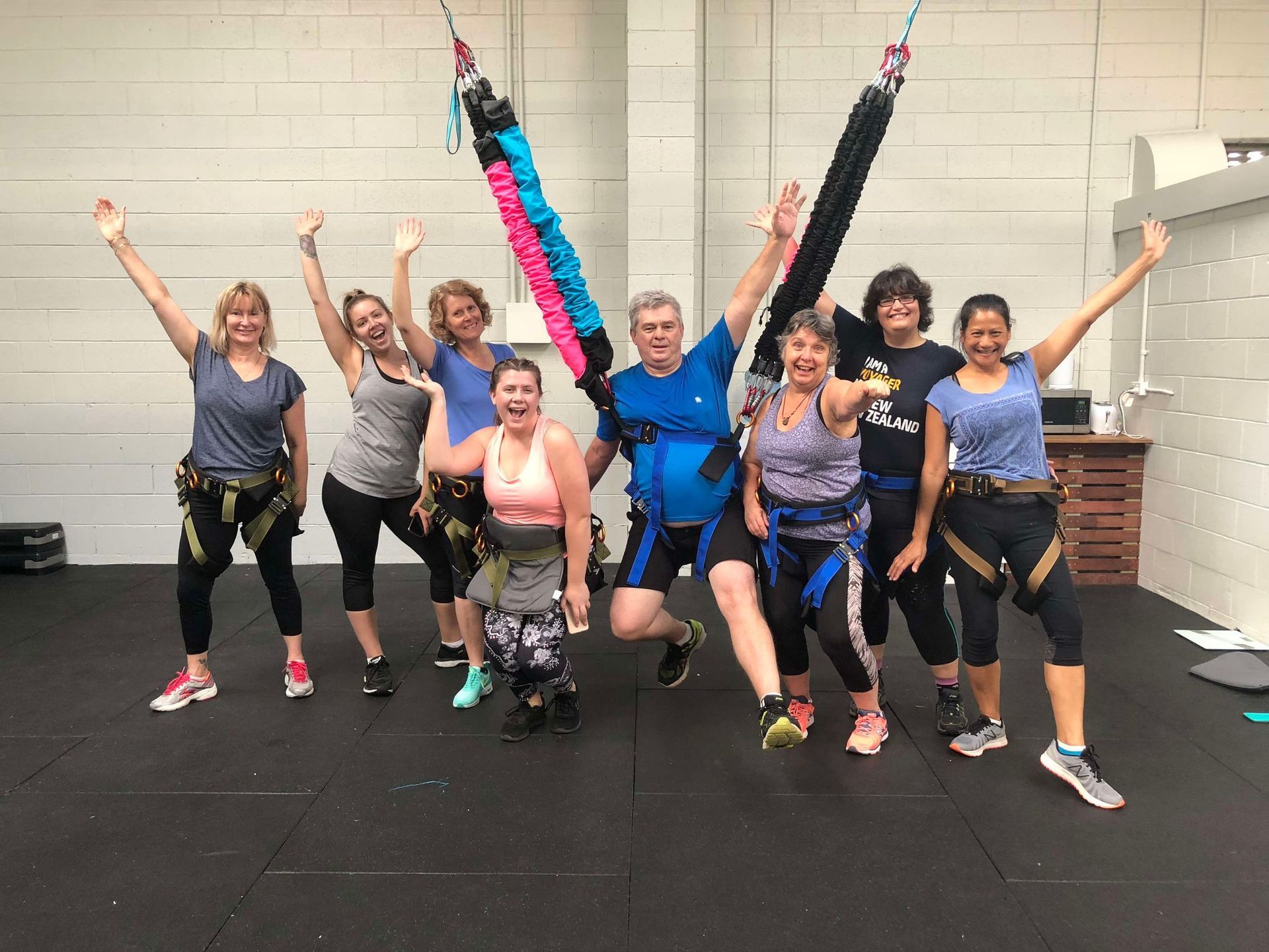 A group of people are jumping in the air in a gym.