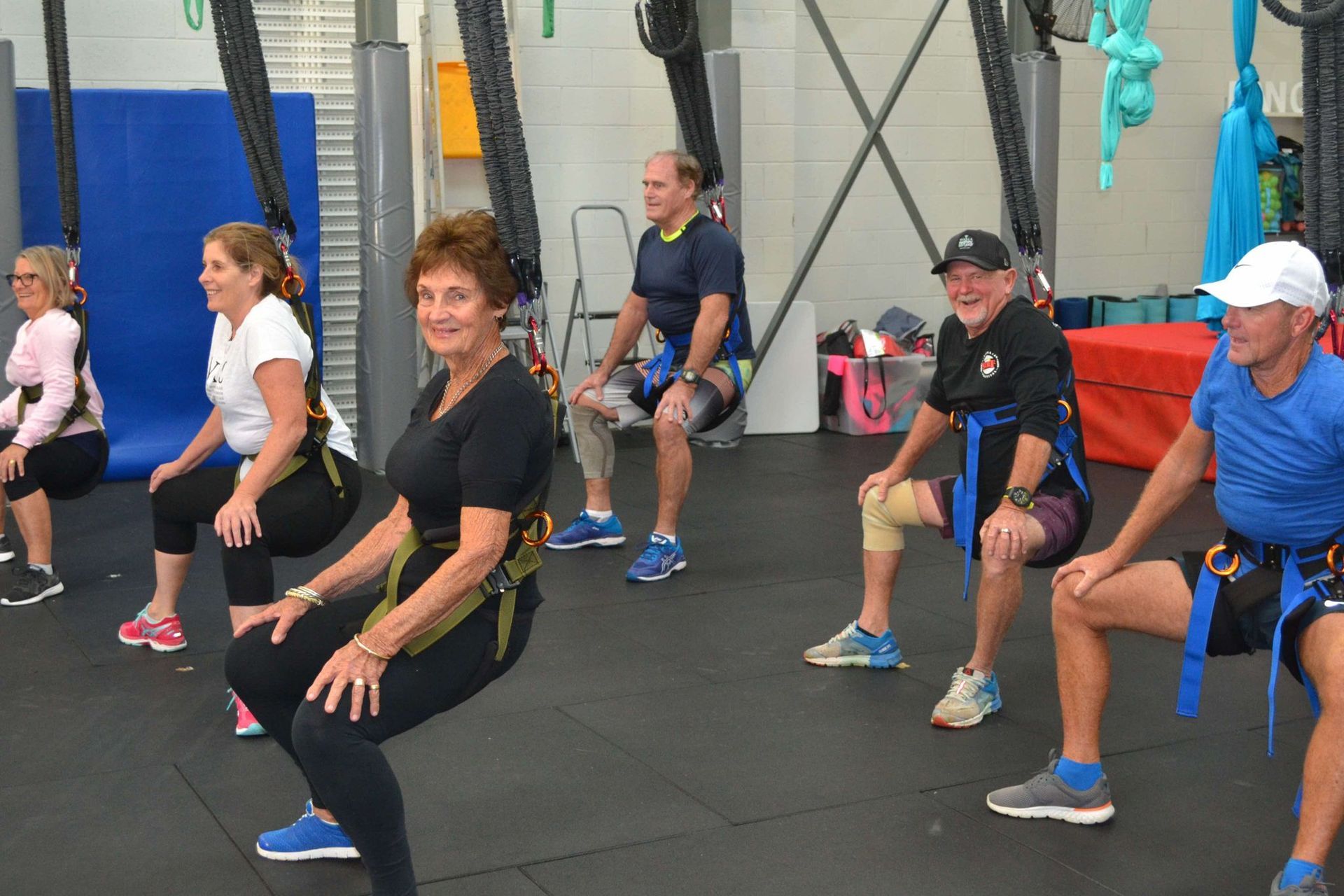 A group of people are doing squats in a gym.