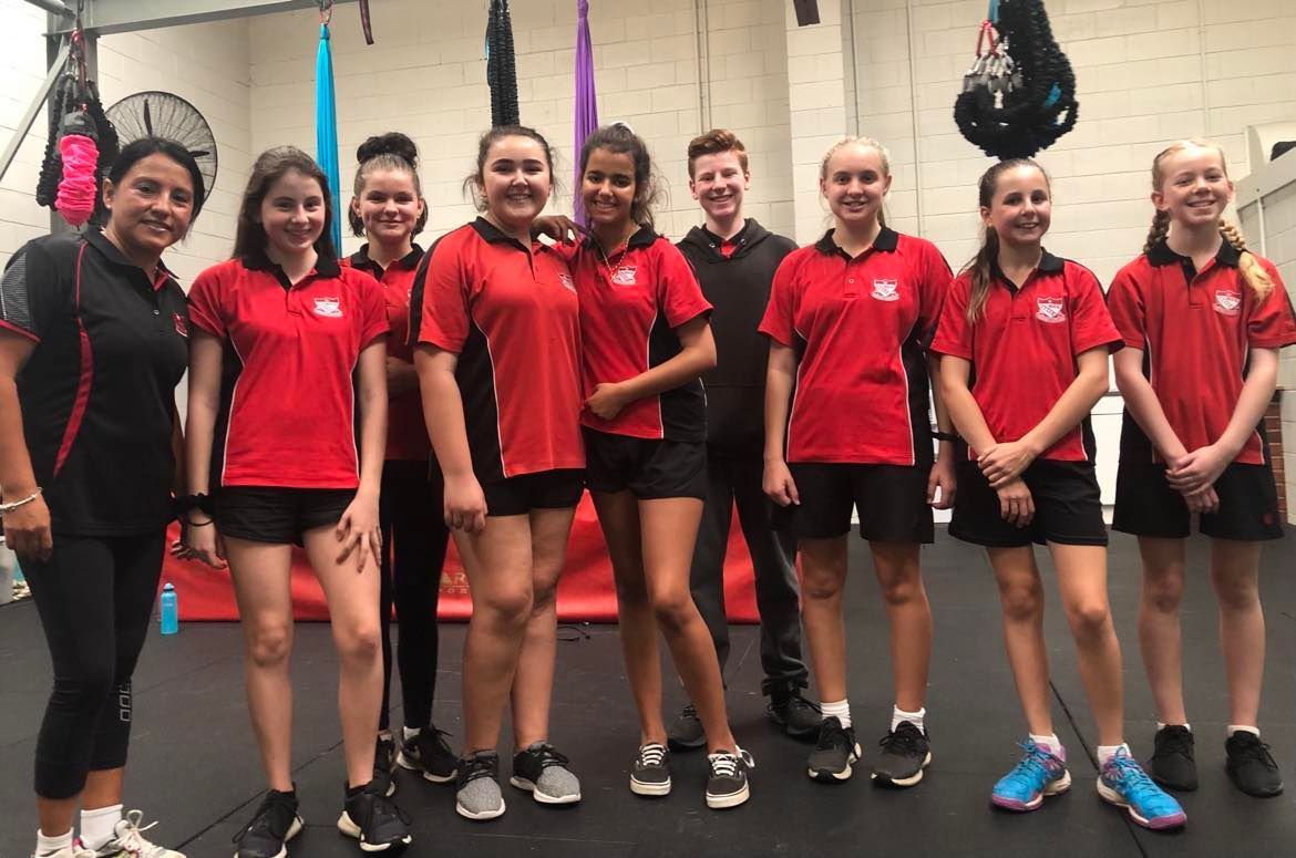 A group of young girls are posing for a picture in a gym.