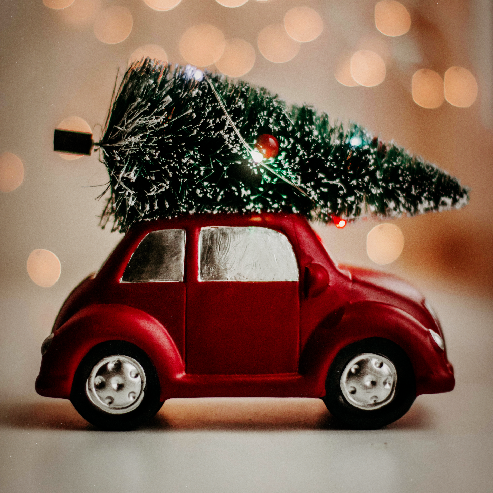 A red toy car with a christmas tree on top of it