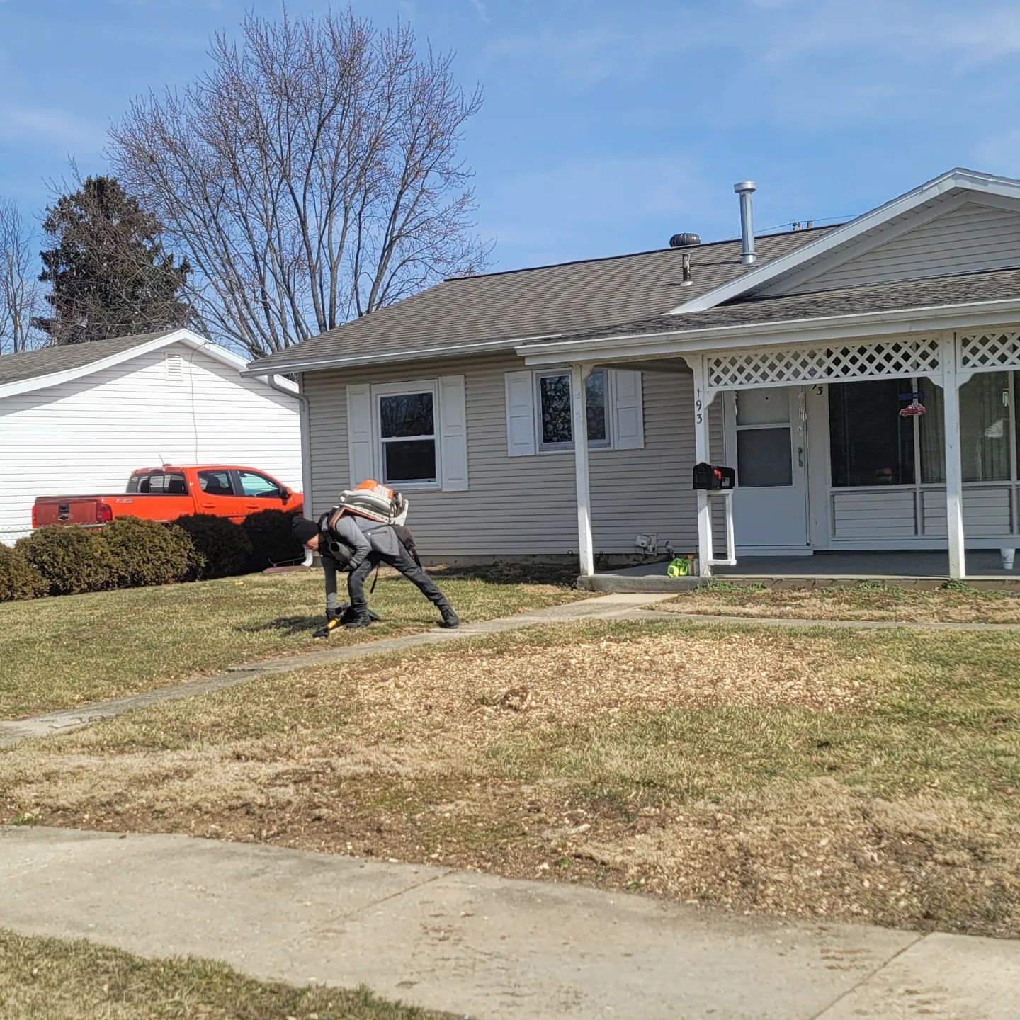 A man is kneeling down in front of a house