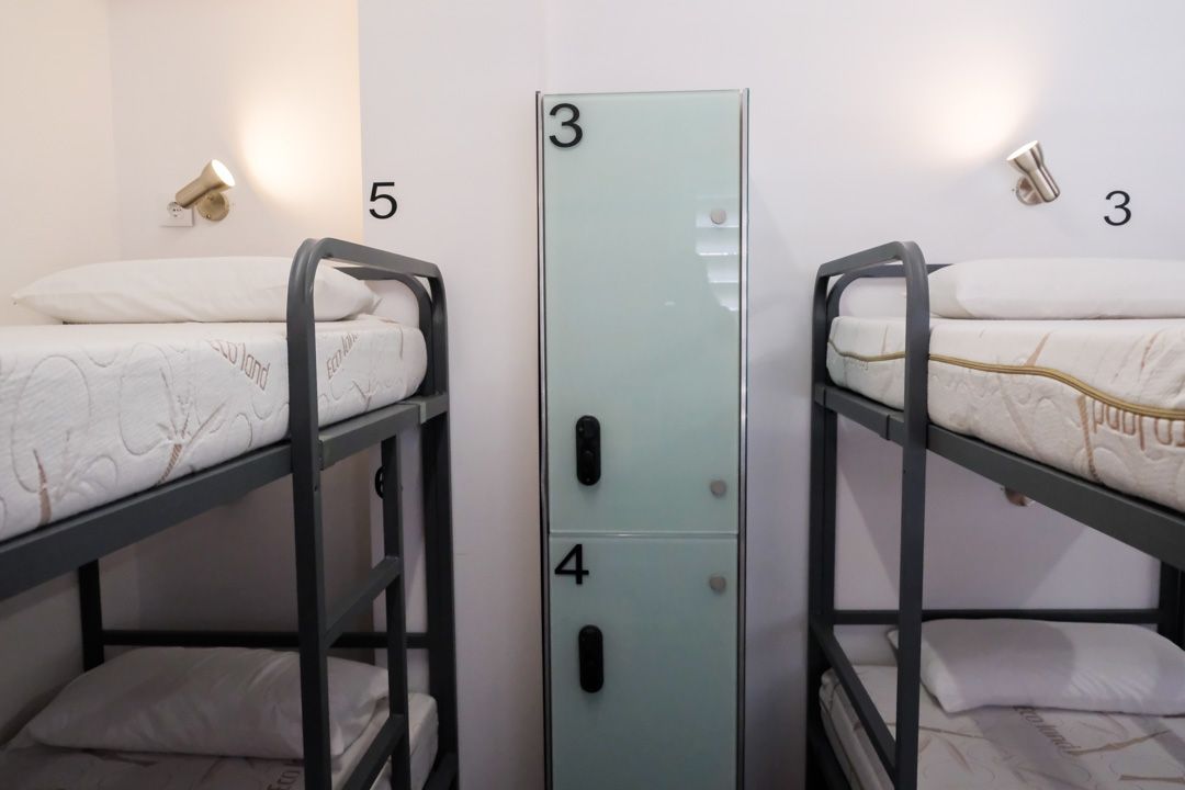 A room with bunk beds and a locker with the number 3 on it.