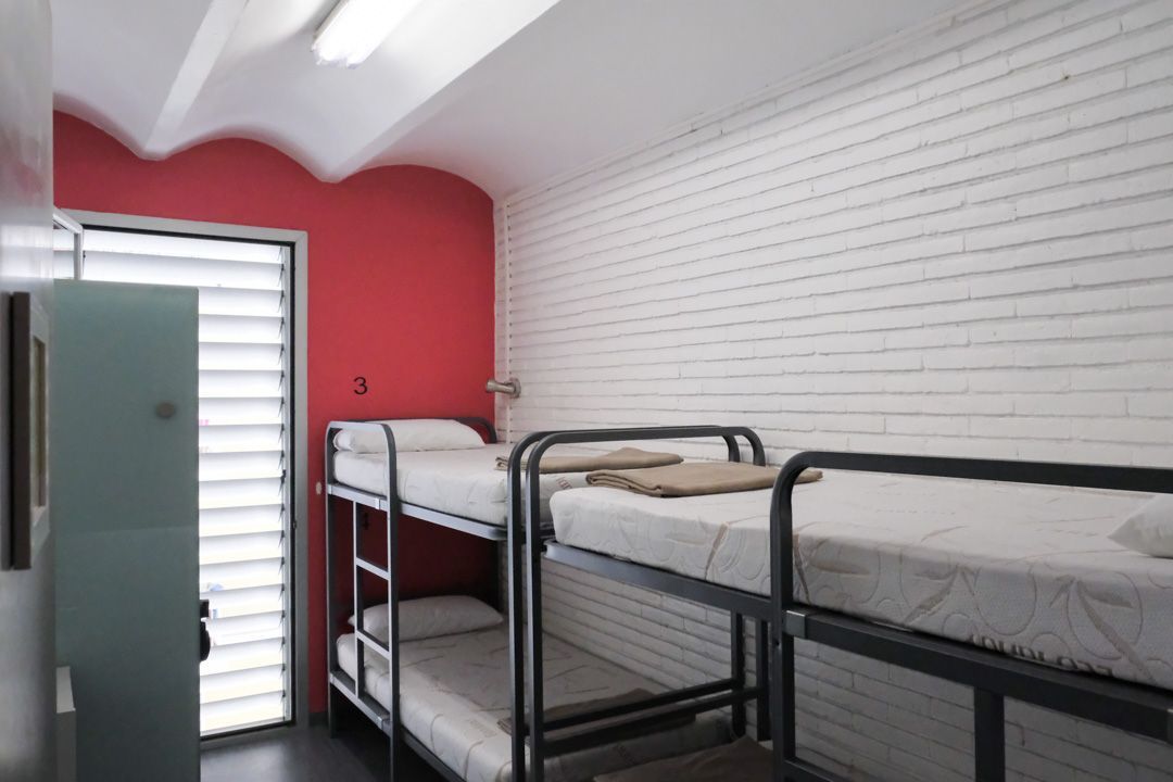 A room with bunk beds and a red wall
