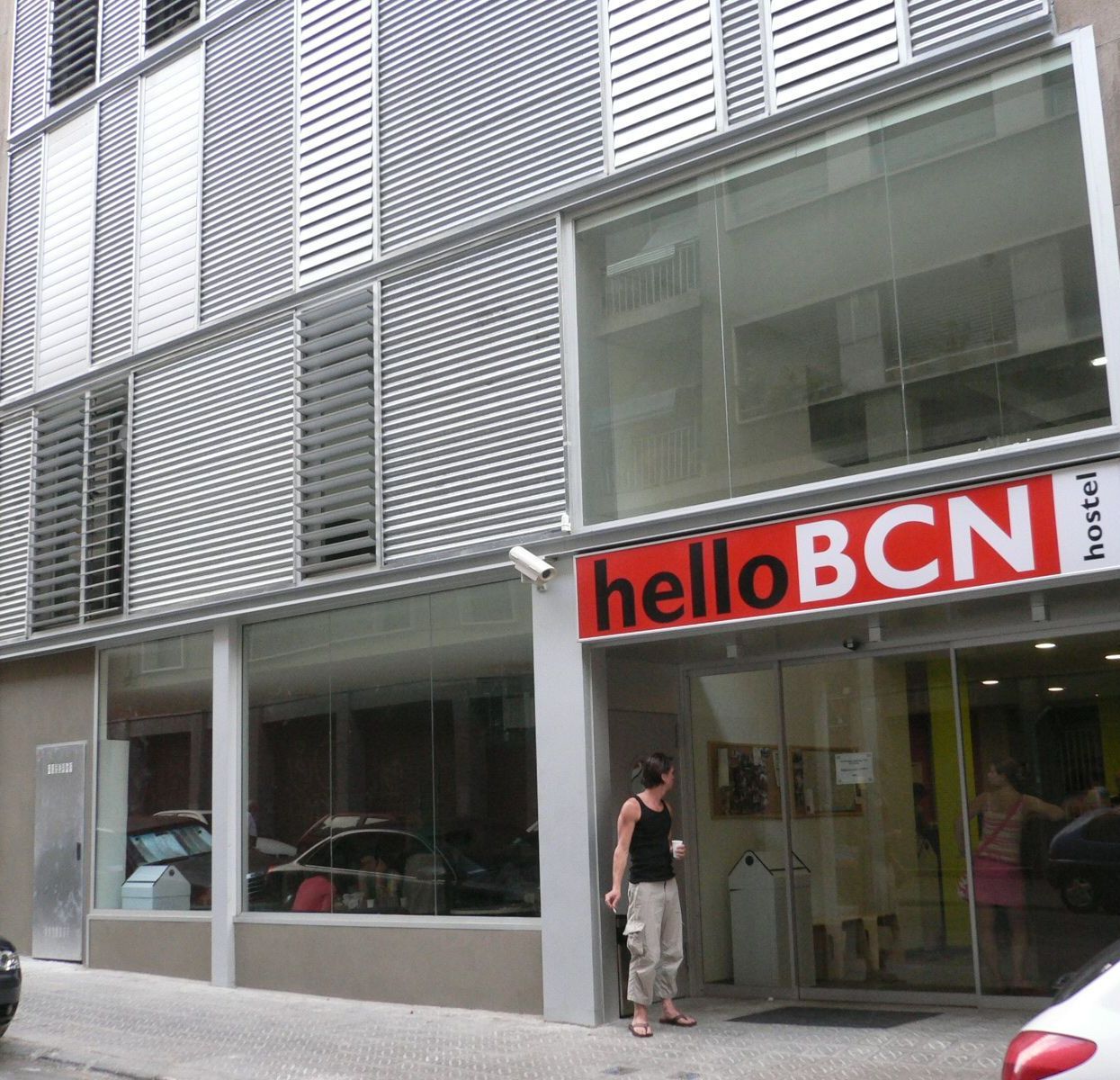 A woman stands in front of a building that says hello bcn