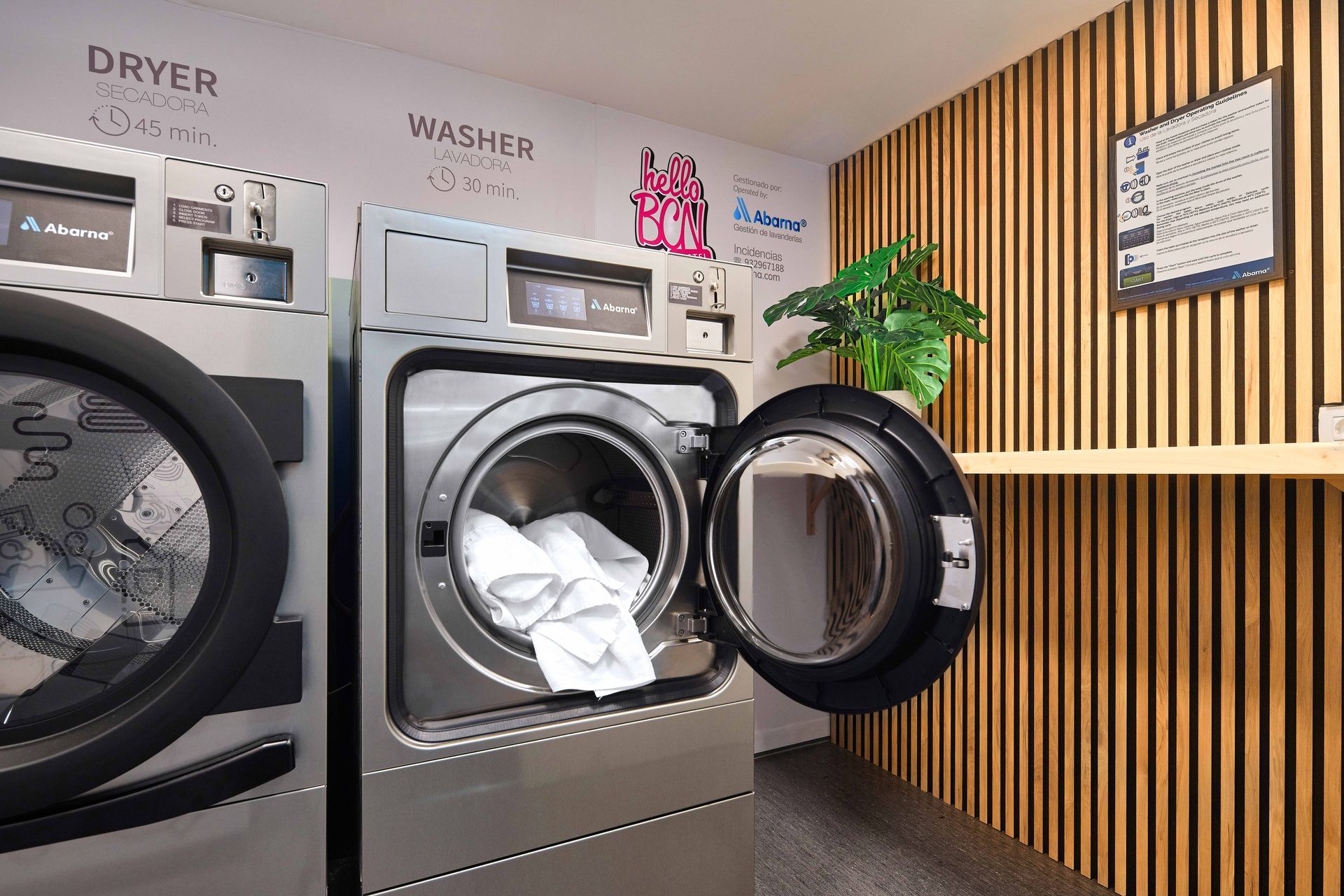 A laundromat with two washing machines and a dryer.